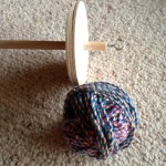 Multicoloured plied yarn and a drop spindle