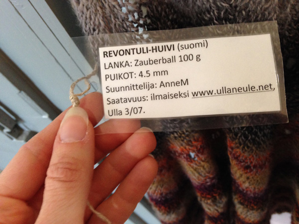 a label on a knitted shawl explaining how much yarn was used and the name of the pattern