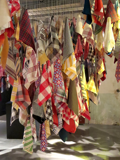 a variety of fabric pieces hanging on ropes