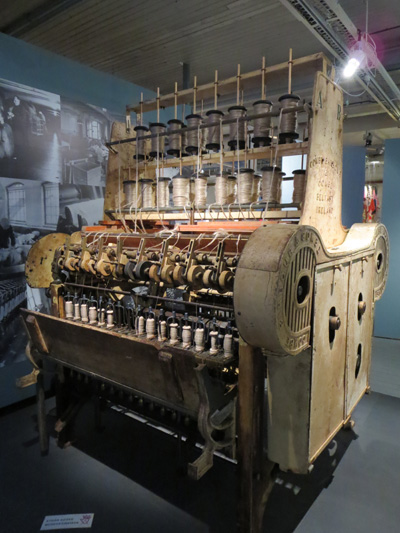 An old industrial machine with spools of yarn